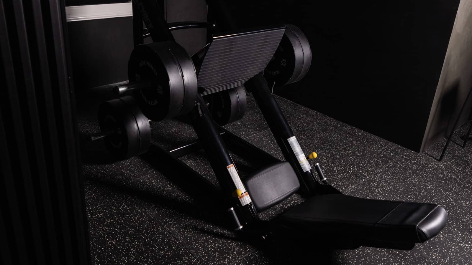 An adjustable bench beside the dumbbell rack