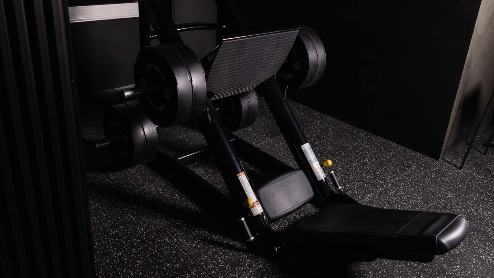 An adjustable bench beside the dumbbell rack